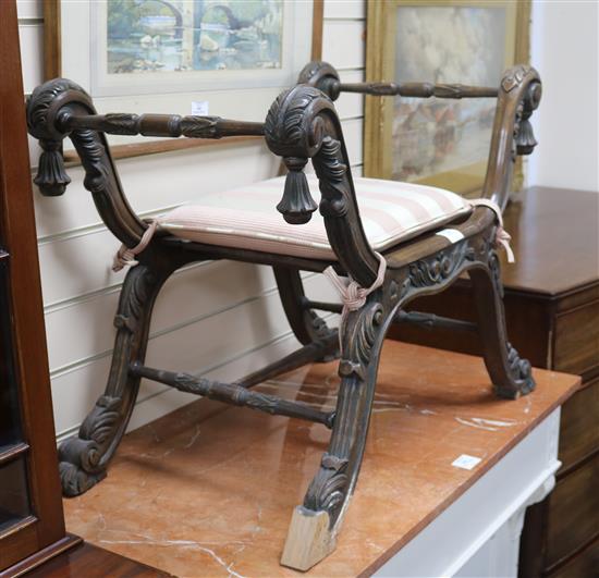 A carved stained beech X shaped dressing stool W.73cm